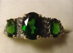 A hallmarked 9ct Gold Ring set with three Chrome Dioxide Stones (green), fourteen small Brilliant