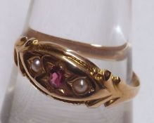 A late Victorian hallmarked 18ct Gold Ring, set with a centre small oval Red Stone and two Seed