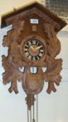 A 20th Century twin weight Wall mounted Cuckoo Clock of typical architectural form, decorated with