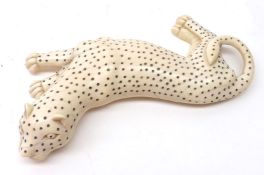 An early 20th Century Carved Ivory Model of Gregory’s Cat in a reclining position with spotted body,