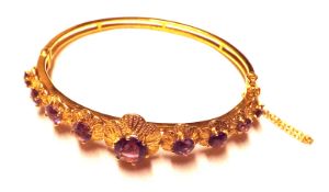 A hallmarked 9ct Gold Bangle in Edwardian style, featuring nine graduated Amethysts to flower head