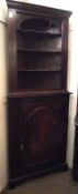 An early 19th Century and later Oak Two Piece Corner Cabinet, the open top section with shaped