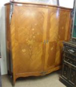 A 20th Century Continental serpentine front Cupboard, the two doors inlaid with floral detail