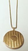 An Art Deco period gold plated circular Locket with banded engine-turned decoration, mounted on a