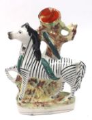 A 19th Century Staffordshire Spill Vase, modelled as a zebra against a tree, raised on an oval