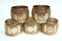 A set of five Eastern white metal Napkin Rings, decorated with chased floral and beaded detail,