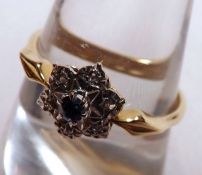 A hallmarked 18ct Gold centre small Blue Sapphire and six small Rose Cut Diamond Cluster Ring