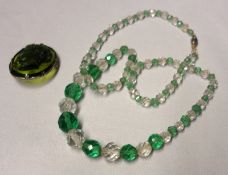 An early 20th Century facetted Green and Clear Glass Necklace, together with a Green Glass Cameo