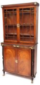 A Regency Mahogany Bookcase Cabinet, the top section with rope moulded cornice, brass roundels,