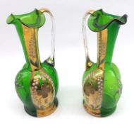 A pair of late 19th/early 20th Century Green Glass Ewers, decorated with gilt highlighted Lily of