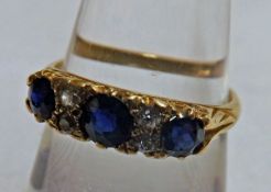 A hallmarked 18ct Gold three Dark Blue Sapphire and four small Old Cut Diamond Ring