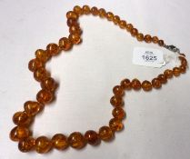 A graduated Amber Bead Necklace, 64cm long and weighing in total approximately 82 gm all in