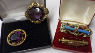 Two Victorian Pinchbeck Framed Brooches with purple stone centres; together with a Tubular Metal Bar