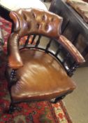 A 19th Century Bow Back Library Chair the bowed back with brown buttoned leather upholstery, spindle