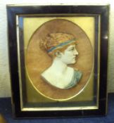 A reproduction composition Plaque in an Ebonised and gilded frame depicting a classical head