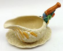 A Clarice Cliff “Celtic Harvest” small Sauceboat on Stand, with coloured relief moulded floral