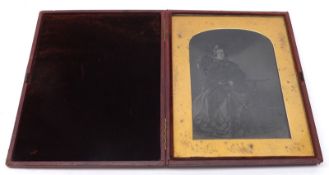 A large Daguerreotype Portrait of a lady seated on chair and holding a parasol with a pedestal table