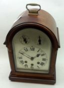 An early 20th Century German Mahogany Cased Mantel Clock, the arched case with cast brass carry