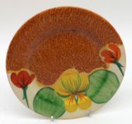 A Clarice Cliff Bizarre Nasturtium pattern Tea Plate with a café au lait ground, black painted