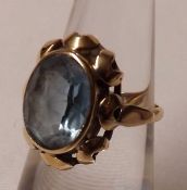 An unmarked yellow metal Oval Aquamarine Dress Ring with pierced surround