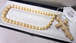 A Victorian finely carved Bone Cross with ivy leaf decoration on a bead necklace, the necklace