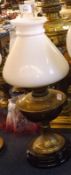 A late 19th/early 20th Century Oil Lamp with opaque glass shade, brass font and pedestal with