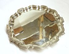 An Edward VIII Salver with moulded edge, plain centre, raised on three scroll feet, 10” diameter,