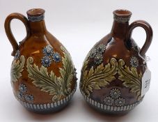 A near pair of Doulton Art Ware Spirit Decanters, decorated with raised design of flowers and