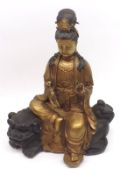 A 20th Century gilded Bronze Model of a seated Deity, seated on Bronze patinated Kaolin clutching