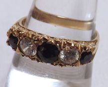 A hallmarked 9ct Gold three Dark Blue Sapphire and two Cubic Zirconia Ring with carved setting