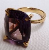 An unmarked yellow metal barrel-shaped Cut Purple Stone Dress Ring
