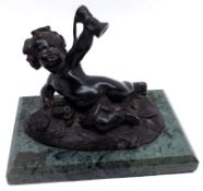 A 20th Century Bronze Model of a recumbent putto, holding aloft a glass of wine on a rectangular