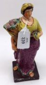 An early 19th Century Staffordshire Figure of a woman with cornucopia of flowers, decorated