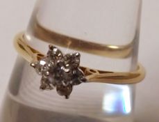 A hallmarked 18ct Gold seven small Brilliant Cut Diamond Ring of flower head design, pierced