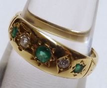 An early 20th Century three Pale Green Emerald and two small Old Cut Diamond Ring in gypsy style,