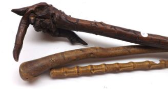 A Primitive type Carved Root Walking Stick; a further Bamboo Cane and a further Rustic Walking