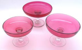 An unusual graduated set of three round Cranberry and Clear Glass Tazzas, from 6” to 8” diameter