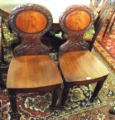 A pair of 19th Century Mahogany Hall Chairs, oval foliate moulded backs, solid seats and bowed