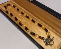An Arts & Crafts style Citrine and Topaz Stone Necklace with Celtic style white metal fastener, 21cm