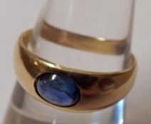 An unmarked yellow metal oval Cabochon Sapphire Ring