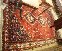 A Caucasian Carpet with triple gull border, central panel of three lozenges, mainly red field within