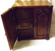 A late 19th/early 20th Century Oak Smokers Cabinet, the two moulded panelled doors each inscribed “