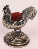 An Edward VII Novelty Pin Cushion, in the form of a cockerel, raised on a round stepped base, Makers
