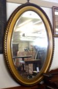 A Gilt Framed Oval Wall Mirror, bevelled glass centre, 31” wide