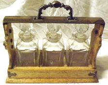 A Bleached Oak and Silver Plated Mounted Three Bottle Tantalus, “Betjemanns Patent”, 13 ¾” wide