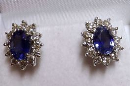 A pair of high grade precious metal centre oval Blue Sapphire and twelve Brilliant Cut Diamond