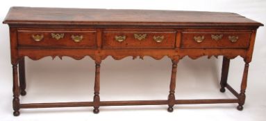 An 18th Century Oak Dresser Base fitted with three short drawers with brass swan neck handles and