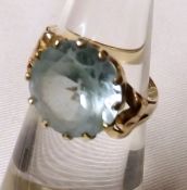 A yellow metal Dress Ring set with a large circular Aquamarine (worn and marks unclear)