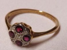 An 18ct Gold and Platinum four small Ruby and five small Old Cut Diamond Ring of flower head design,