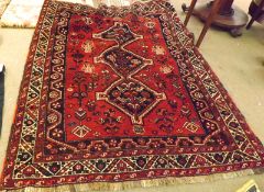 A Caucasian Rug with multi-gull border and central pattern of three joined lozenges, mainly red,